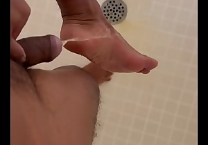 Asian man pissing on feet in the shower