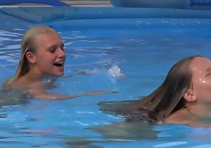 Two beautiful girls swimming and trample by the pool