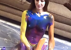 Sexy petite bitch hand paints her skin on the floor